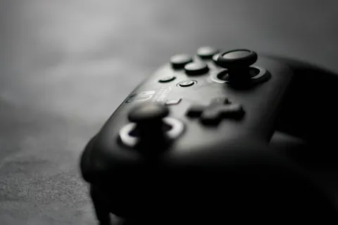 Manette Nintendo Switch Pro noire photographiée de trois quarts sur une surface sombre