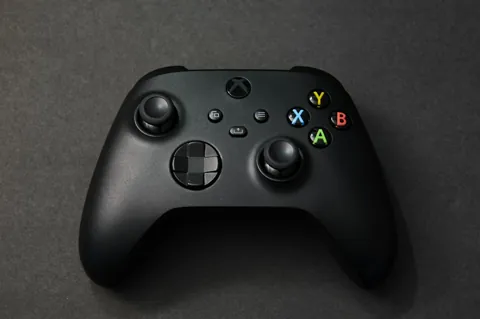 Manette Xbox Series Carbon Black noire photographiée de face sur une table, bouton de partage visible