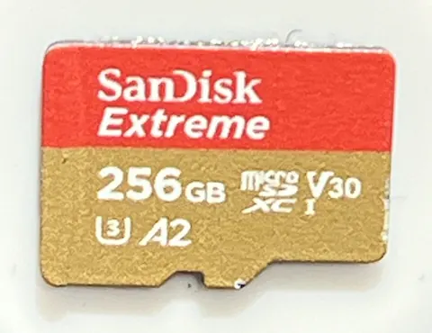 Carte microSD SanDisk Extreme rouge et dorée, photographiée de face sur fond clair