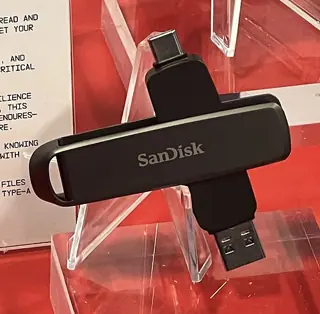 Clé USB SanDisk Extreme PRO Dual Drive noire, avec ses connecteurs USB-C et USB-A ouverts sur un présentoir rouge