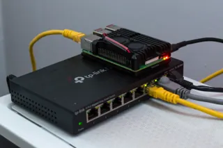 Raspberry Pi posé sur un switch TP-Link TL-SG108E, avec plusieurs câbles branchés