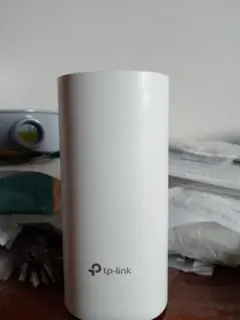 Borne TP-Link Deco M4R blanche photographiée de face sur une table, une des 2 bornes du coffret