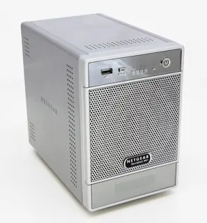 Photo illustrative d’un ancien NAS Netgear gris en vue de trois quarts, boutons et grille en façade ; autre référence, pas la photo exacte de QNAP TS-264-8G ; baies, disques, mémoire et fonctions non déduits du visuel