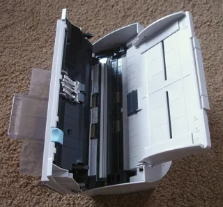 Ancien scanner de documents Fujitsu ouvert montrant son chemin papier ; photo illustrative, pas la photo exacte de Brother DS-940DW