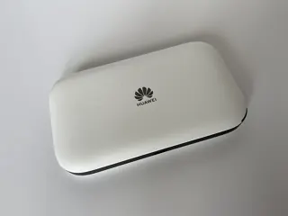 Ancien routeur mobile Huawei blanc et noir vu de dessus ; photo illustrative, pas la photo exacte de TP-Link M8550 ; fonctions non déduites du visuel
