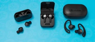 Écouteurs JLab noirs, embouts, crochets et boîtiers sur fond turquoise ; photo illustrative, pas la photo exacte de Shokz OpenFit Air 2 ni preuve du coffret fourni