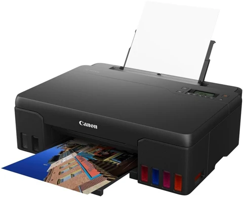 Canon PIXMA G550 noire, vue de trois quarts avec papier chargé et tirage photo en sortie